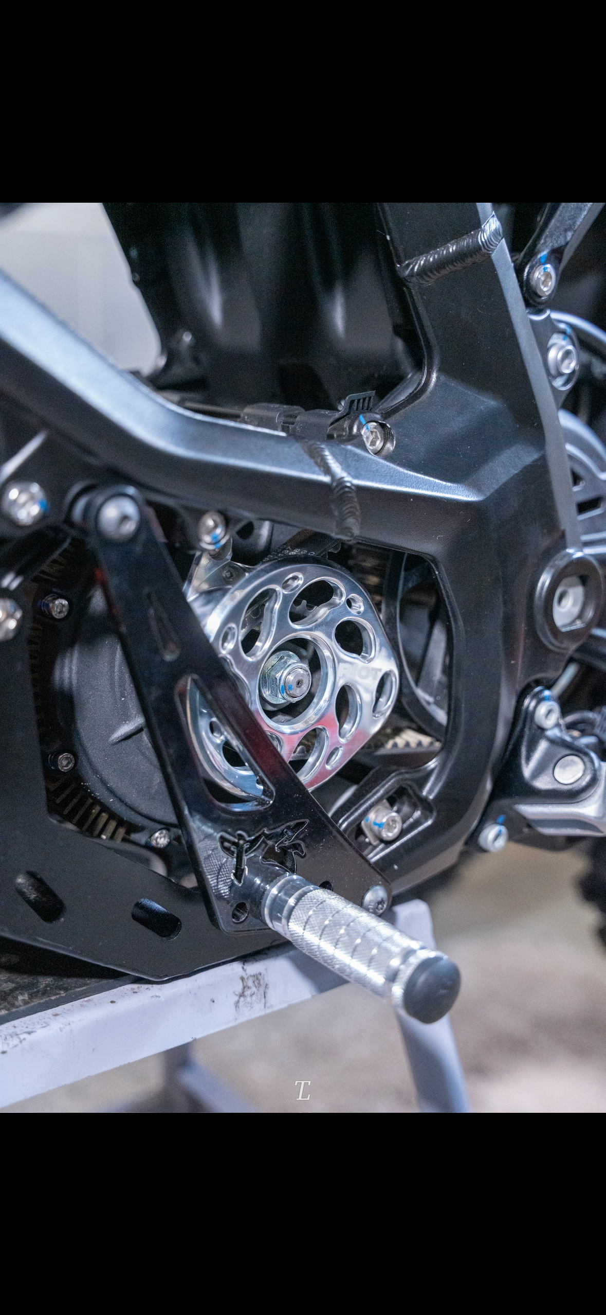 Polished Riot Racing motor cover installed on an Ultra Bee, viewed from above the footpeg.